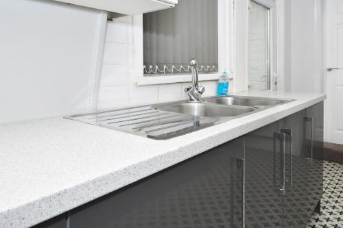 a kitchen counter with a sink and a mirror at Townhouse @ Lord Street Crewe in Crewe