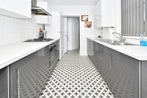 a kitchen with a black and white tile floor at Townhouse @ Lord Street Crewe in Crewe