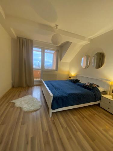 a bedroom with a bed and a wooden floor at 7 people - 1 price - Cozy attic apartment in Prešov