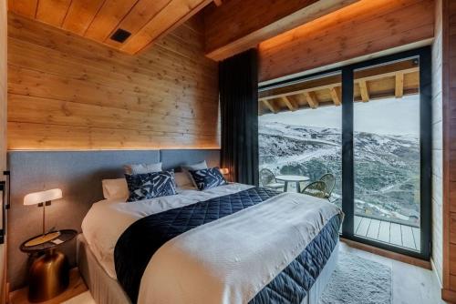 Un dormitorio con una cama y una ventana grande. en Luxury Mountain Chalet in Sierra Nevada, en Sierra Nevada