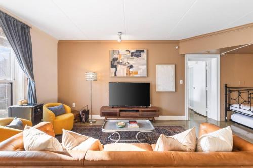 a living room with a couch and a tv at Pool, Walk Restaurants plus Bars on Famous Music Row in Nashville