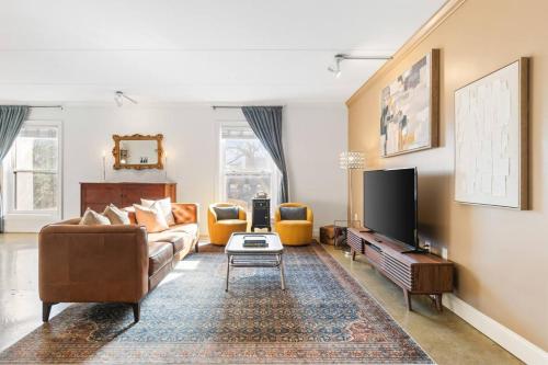 a living room with a couch and a tv at Pool, Walk Restaurants plus Bars on Famous Music Row in Nashville