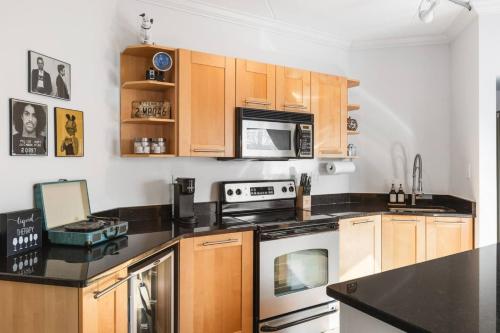 a kitchen with black counter tops and wooden cabinets at Pool, Walk Restaurants plus Bars on Famous Music Row in Nashville