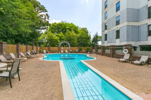 a swimming pool with chairs and a building at Pool, Walk Restaurants plus Bars on Famous Music Row in Nashville