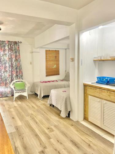 a living room with two beds and a kitchen at Bananaquit Tobago -Stay Near the Beach in Crown Point