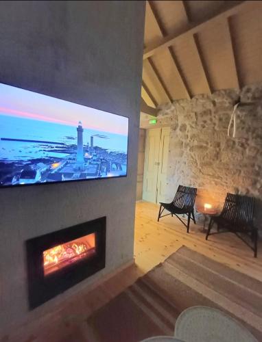 a living room with a fireplace and a tv on a wall at Exclusive Pena Rio in Ribeira de Pena