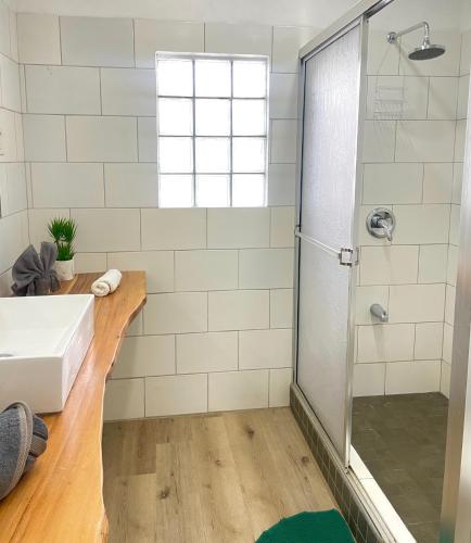 a bathroom with a sink and a shower at Bananaquit Tobago -Stay Near the Beach in Crown Point
