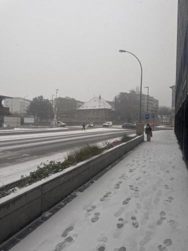 a sidewalk with footprints in the snow next to a road at Apartment Martigny in Martigny-Ville