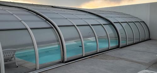 a glass greenhouse with a swimming pool in it at Quequen - Vista al Mar in Quequén
