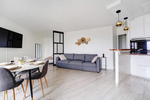 un salon avec un canapé et une table dans l'établissement Babylone 2 premium, à Le Pré-Saint-Gervais