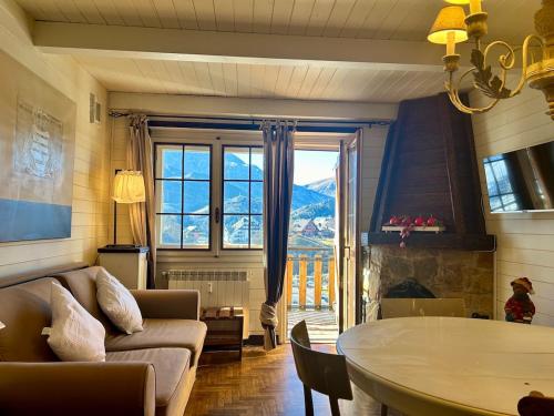 a living room with a couch and a table at Trilocale a due passi dalle piste con balcone in Prato Nevoso