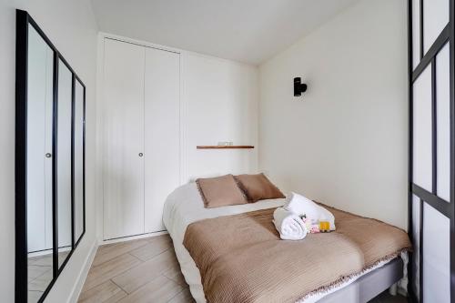 ein kleines Schlafzimmer mit einem Bett und einem Spiegel in der Unterkunft Babylone 2 premium in Le Pré-Saint-Gervais