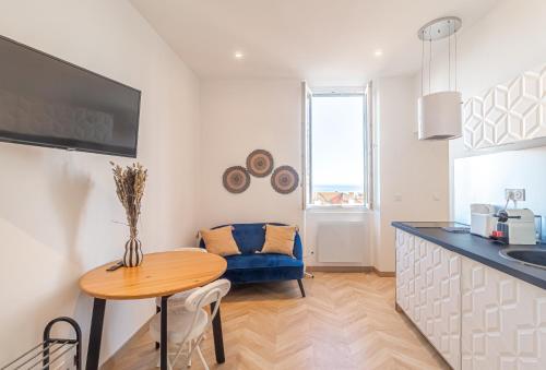 une cuisine avec une table et un canapé bleu dans l'établissement T2 Town Center, Casino, à Beausoleil