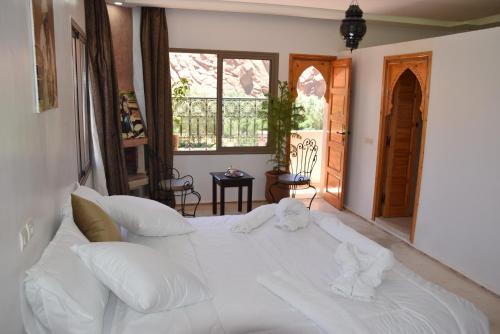 a large white bed in a room with a window at Canyon Dades Guest House in Akedim Msemrir