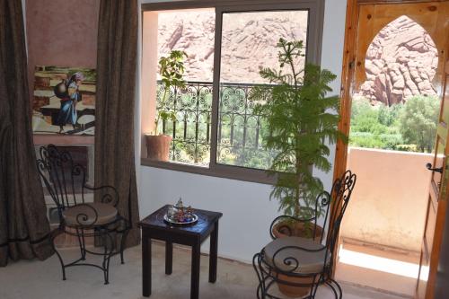 a room with chairs and a table and a window at Canyon Dades Guest House in Akedim Msemrir