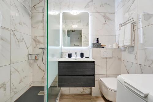 ein Badezimmer mit Waschbecken und Spiegel in der Unterkunft Babylone 2 premium in Le Pré-Saint-Gervais