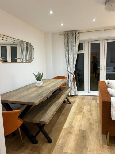 a dining room with a wooden table and chairs at Kings Reach Slough nr Legoland and Ascot Stylish Homely House Sleeps Eight in Langley Marish