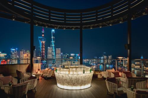 上海市にあるHyatt on the Bund Shanghai - a Grand Hyatt hotel, most centrally located at HuangPu river banks in downtownの夜の街の景色を眺められるレストラン