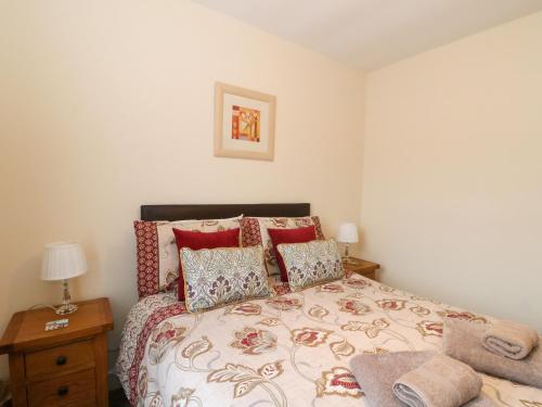 a bedroom with a large bed with red pillows at 6 Aonachan Gardens in Spean Bridge