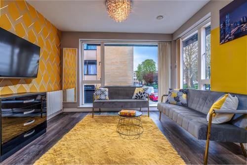 a living room with a couch and a tv at Quiet garden view flat by Portland Square in Bristol
