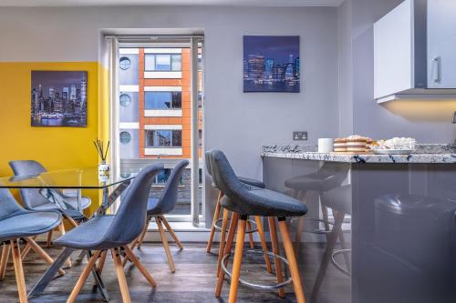 a kitchen with a glass table and stools at Quiet garden view flat by Portland Square in Bristol