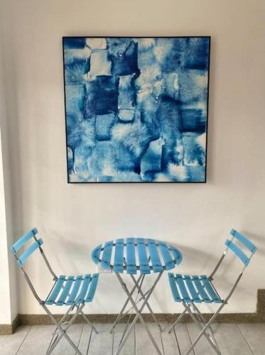 two chairs and a table in front of a painting at Las Casitas En Punta in Punta Blanca
