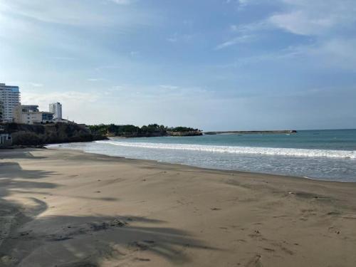 an empty beach with the ocean and buildings at Las Casitas En Punta in Punta Blanca