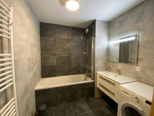 a bathroom with a tub and a sink and a shower at Perle de Savoie B102 in Châtel