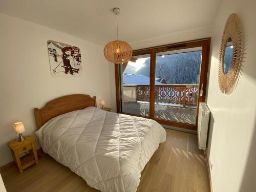 a bedroom with a bed and a large window at Perle de Savoie B102 in Châtel