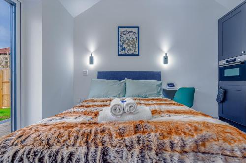 a bedroom with a bed with towels on it at Cozy bungalow near Concorde museum w/ backyard in Bristol