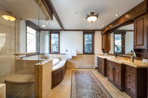 a large bathroom with a tub and a sink at Altitude 166-1 On the village 9bdr in Mont-Tremblant