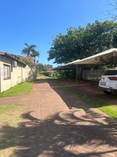 a brick road next to a building with a car at Amanzimtoti , 36 Ocean Breeze ,warner beach, kingsburg in Kingsburgh