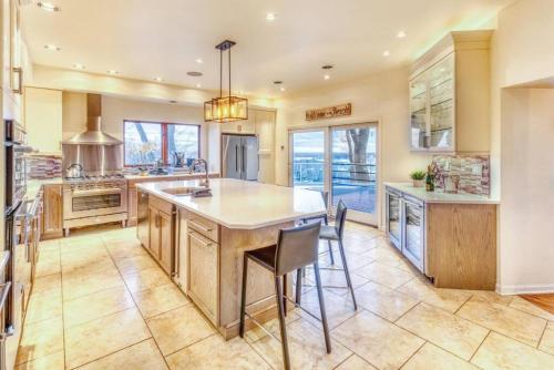 a kitchen with a large island with chairs in it at Villa Santorini The Addition in Gary