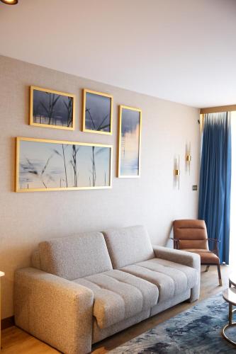 a living room with a couch and some pictures on the wall at Hotel Mazurski Raj in Ruciane-Nida