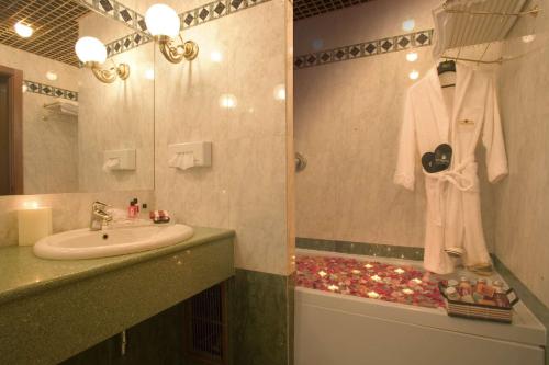 a bathroom with a sink and a shower with a mirror at Hotel Motel Visconteo in Binasco