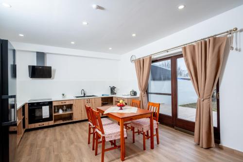 a kitchen and dining room with a table and chairs at Rózsa Vendégház in Kastélyosdombó