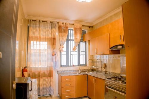 a kitchen with a sink and a stove and a window at Winston Homes in Kigali