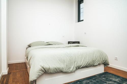 - une chambre dotée d'un lit avec un mur blanc dans l'établissement Hostel Bords de Marne 1, à Gournay-sur-Marne