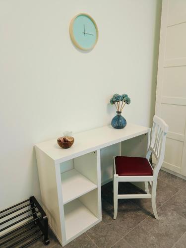 a white desk with a chair and a clock at Villa Petra - Πέτρα in Alpignano