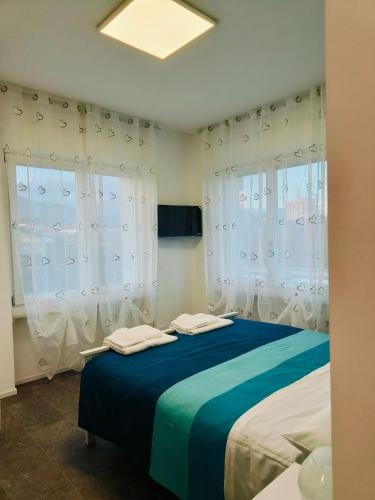 a bedroom with a blue bed with white curtains at Villa Petra - Πέτρα in Alpignano