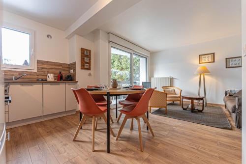 une cuisine et un salon avec une table et des chaises dans l'établissement Appartement Nael - LES GETS, en plein centre et au pied des pistes, aux Gets
