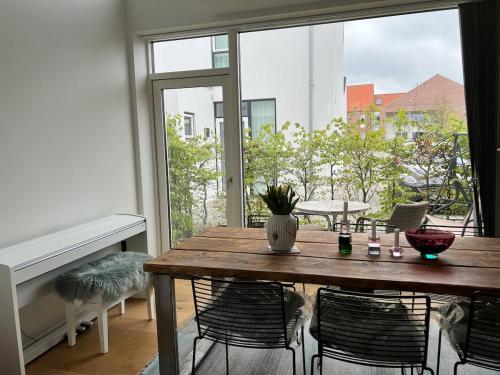 a dining room with a table and a large window at Cozy little house in Aalborg