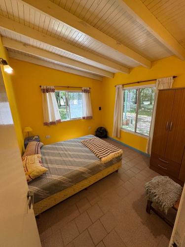 a bedroom with a bed in a yellow room at La rosadita in San Clemente del Tuyú