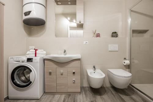 a bathroom with a washing machine and a toilet at Siena Living Apartment in Siena
