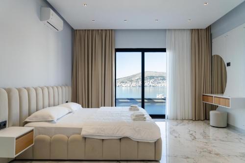 a bedroom with a large bed and a large window at Day Lux Superior Apartments in Sarandë