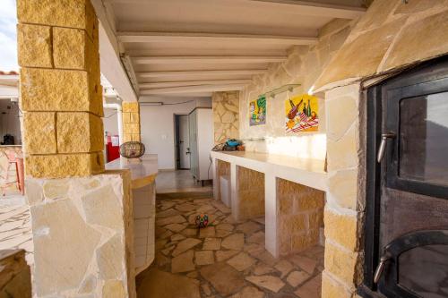 a large room with a stone wall and a kitchen at Luxury Private Complex in Albir