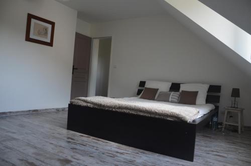 a bedroom with a bed in a white room at Maison Reine-Claude in Esbly