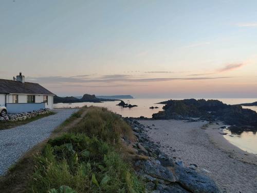 a house on the shore of a body of water at Harbour Cottage Ballintoy in Ballintoy