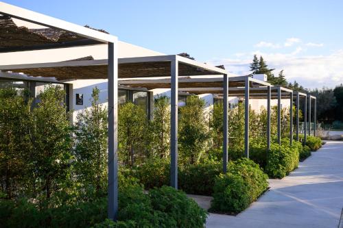 a row of poles in a parking lot with bushes at Quinta da Amendoeira - Évora - The Farmhouse in Évora