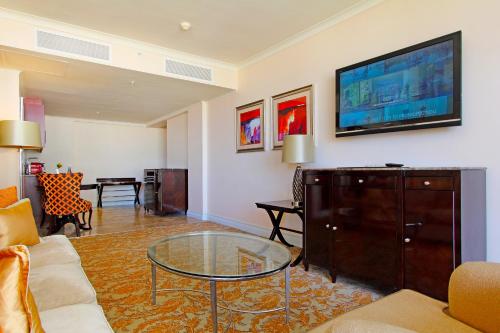 a living room with a couch and a tv on a wall at Taj Cape Town - Spacious 5 star luxury residence with kitchenette in Cape Town